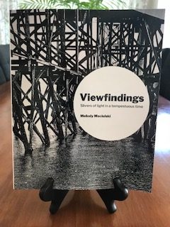 Large display of "Viewfindings' book cover, showing pilings in water.
